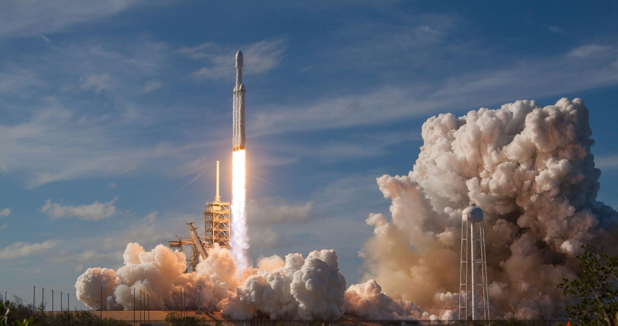 SpaceX rocket launch with a bright exhaust plume against the sky